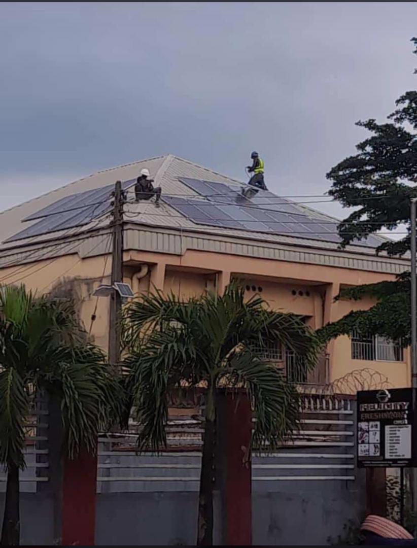 People mounting solar panels on a house